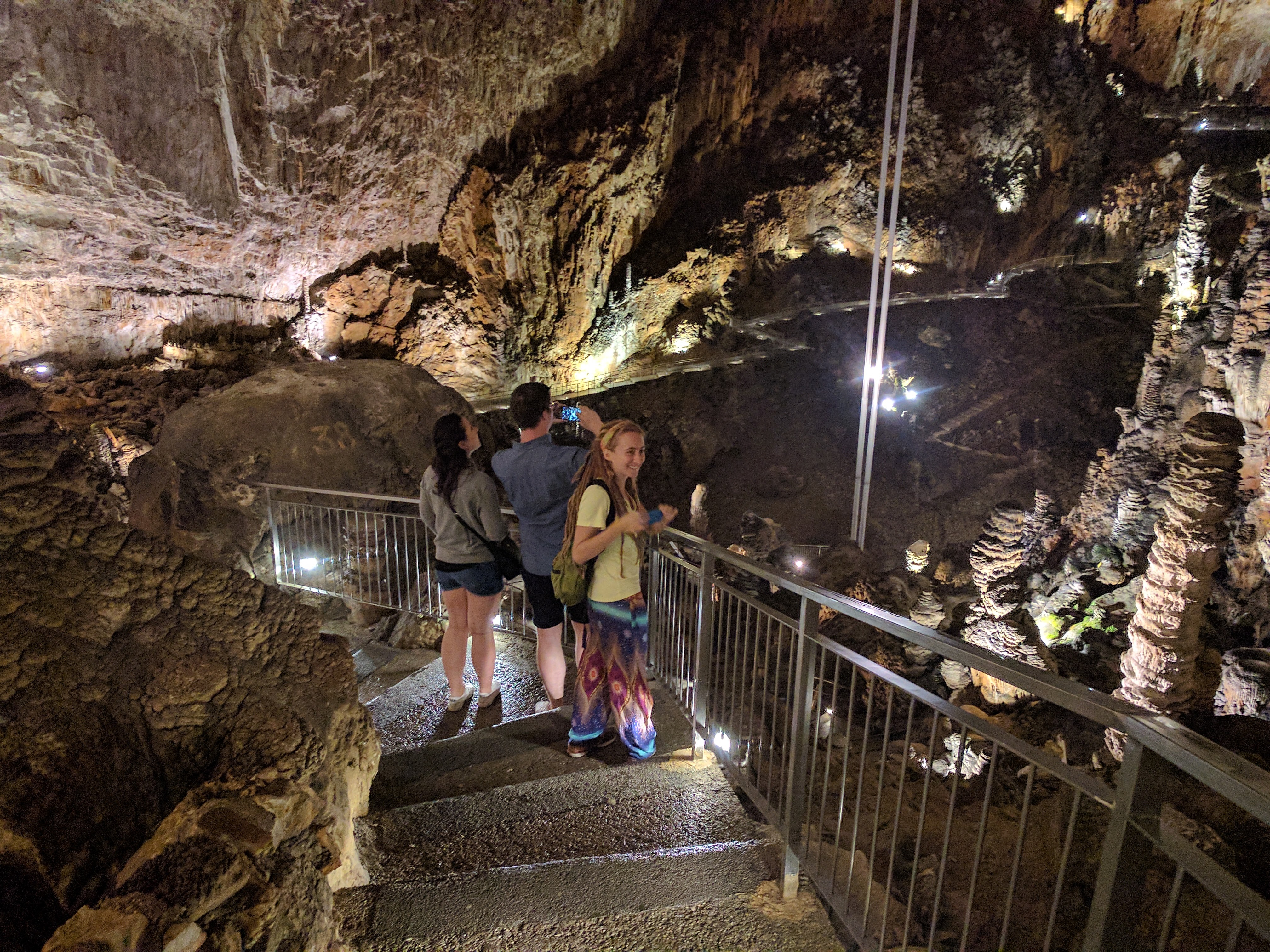 Some people on some steps leading into a giant cave