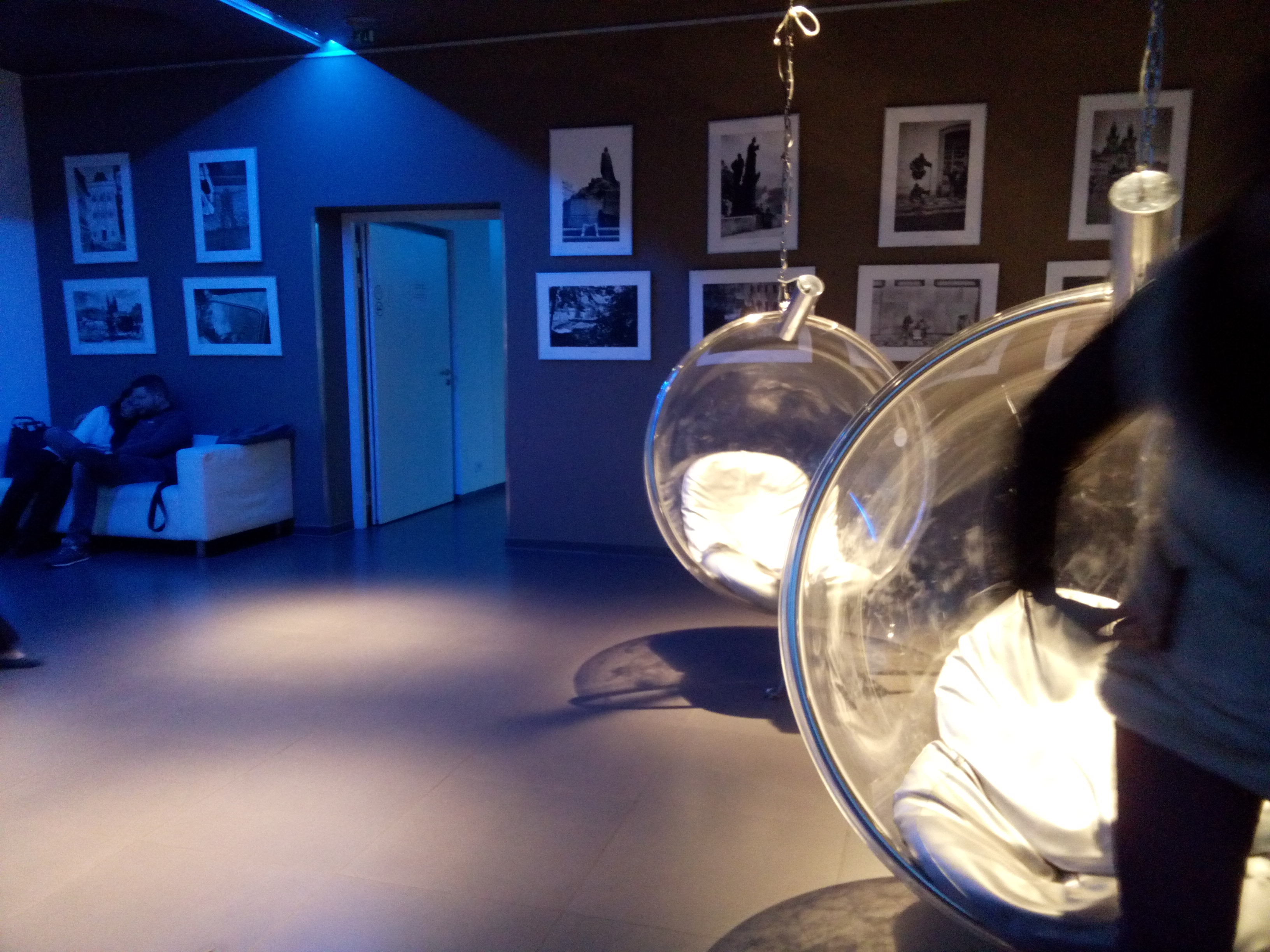 Transparent hanging egg-seats in a blue and grey dimly lit room