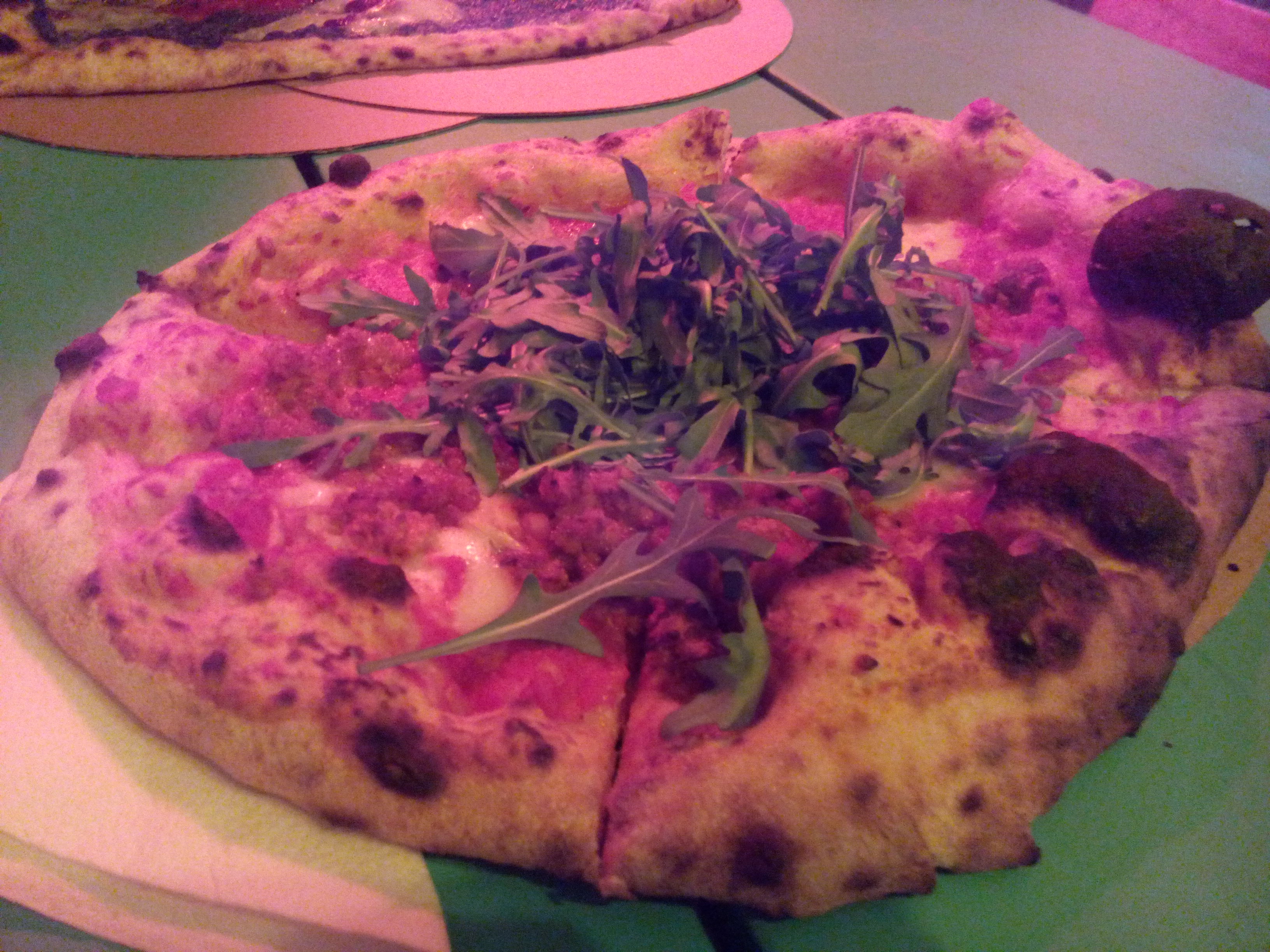 Dimly lit pizza with rocket on