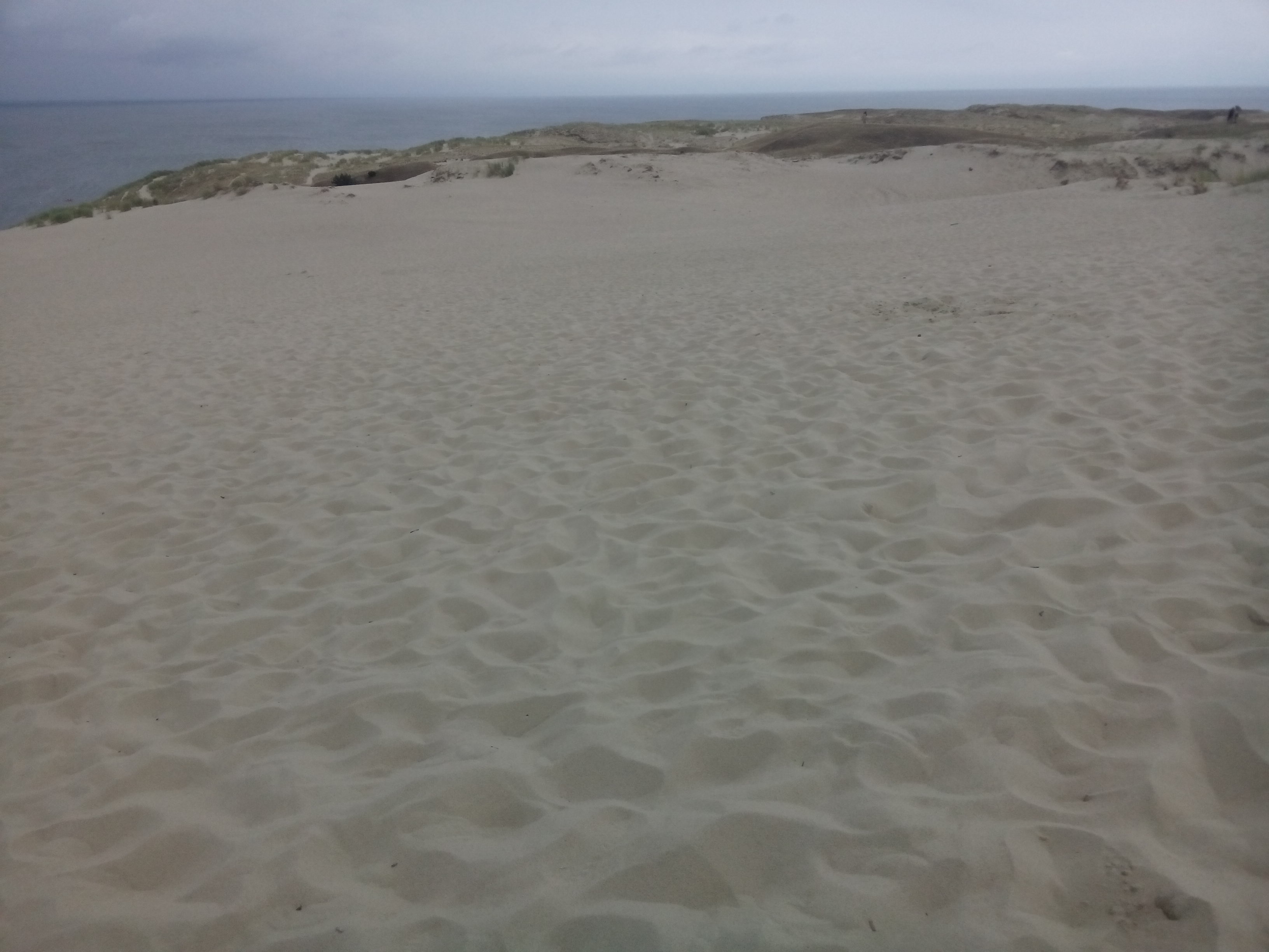An expanse of soft sand reaches into the distance, and the sea is visible beyond