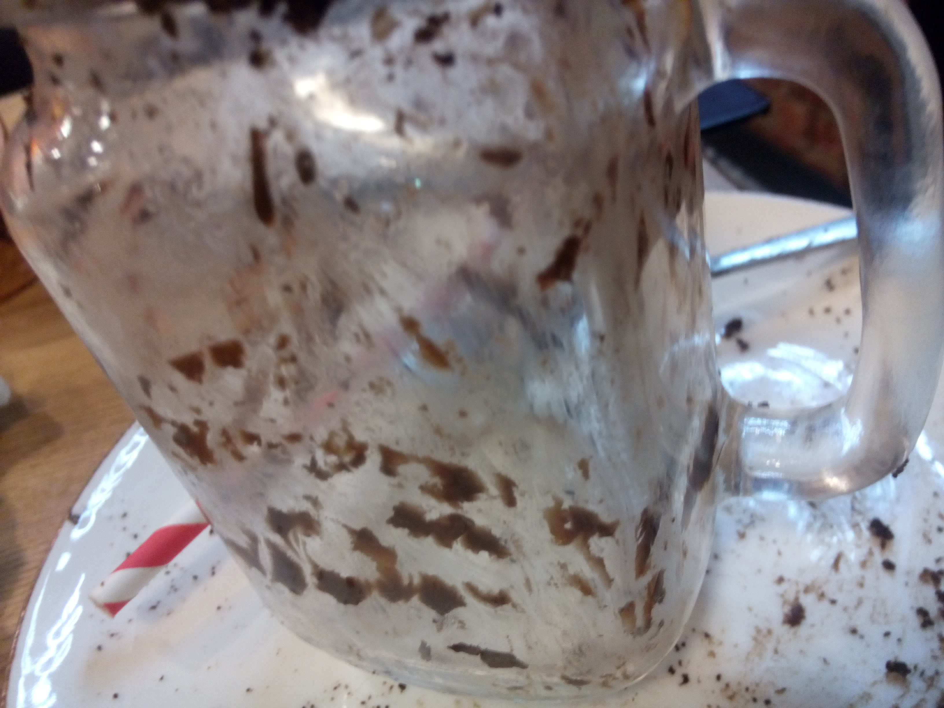 An empty jar-glass with some tiny remains of chocolate on the inside