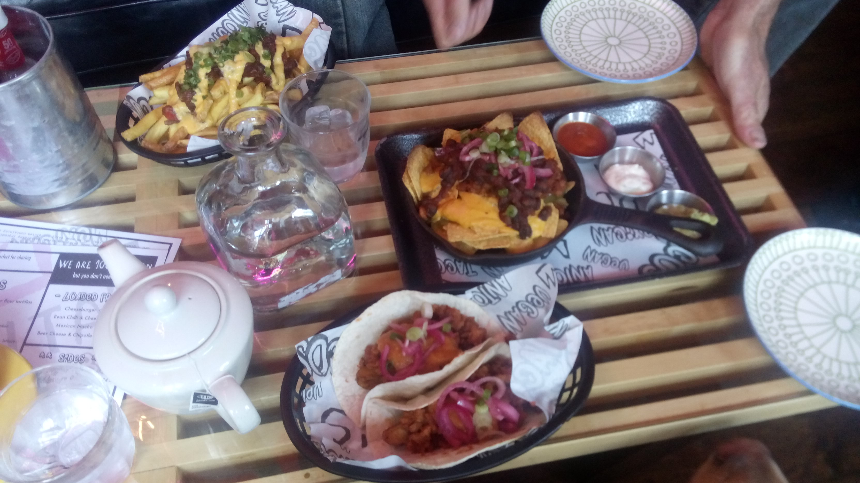 A table spread with dishes of tasty Mexican food and a teapot