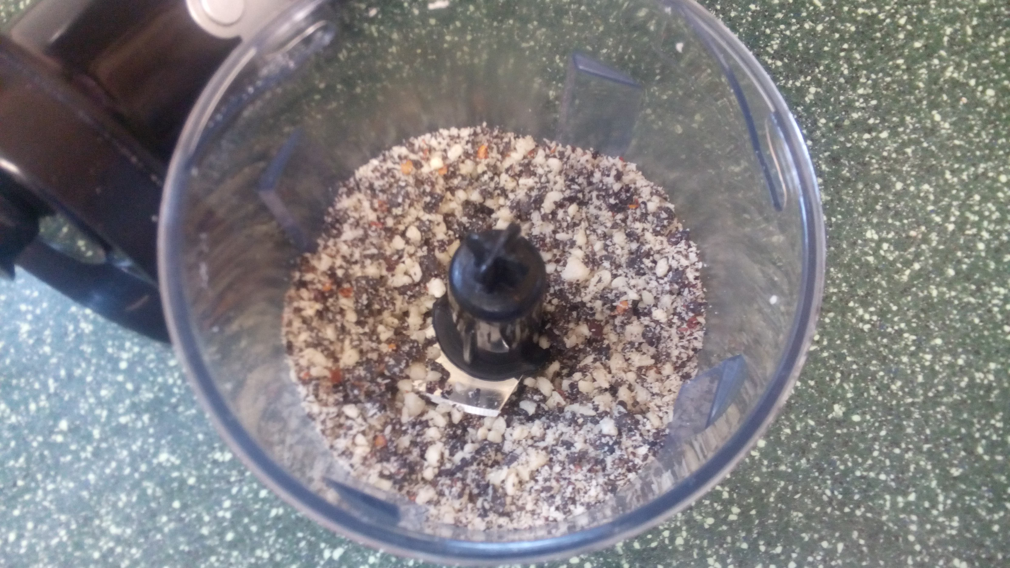 a small food processor containing a mixture of things all ground up