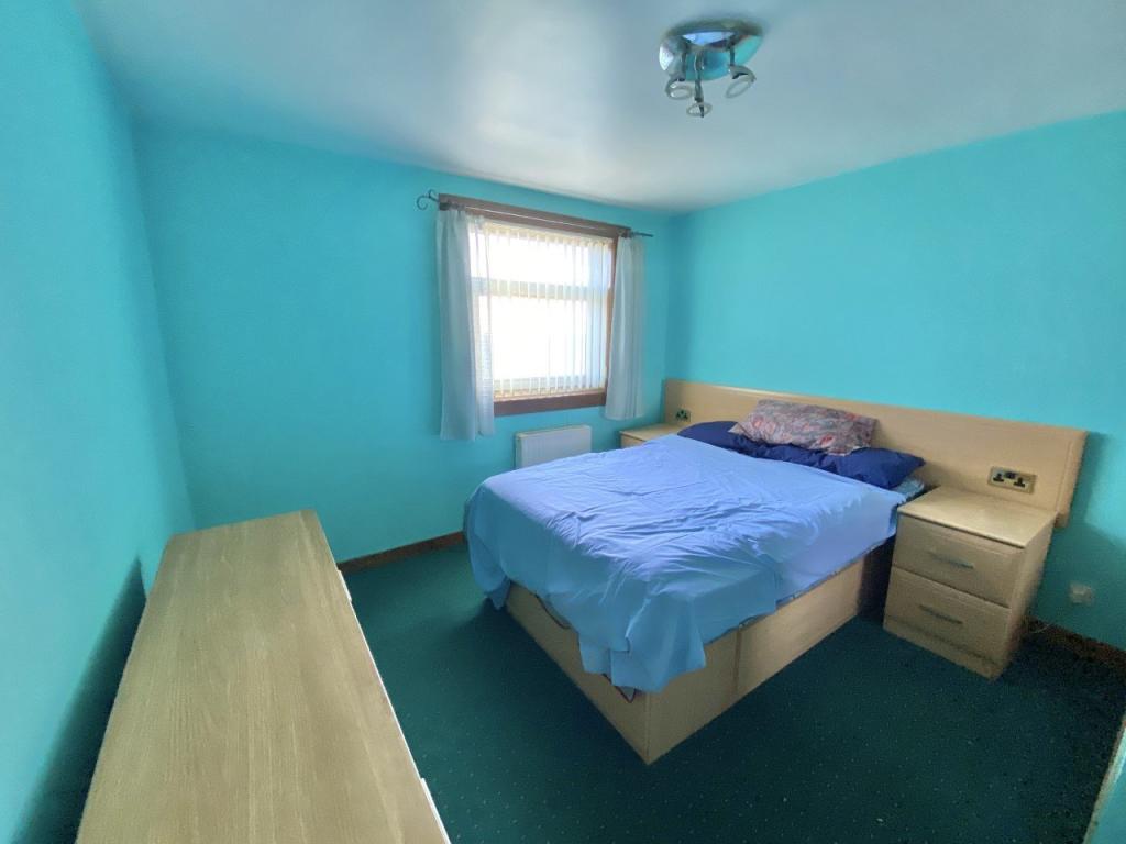 Before: Bedroom with builtin cupboards each side of the bed, bright blue walls, green carpet